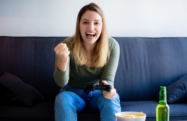 Bella donna seduta sul divano e guardare la tv