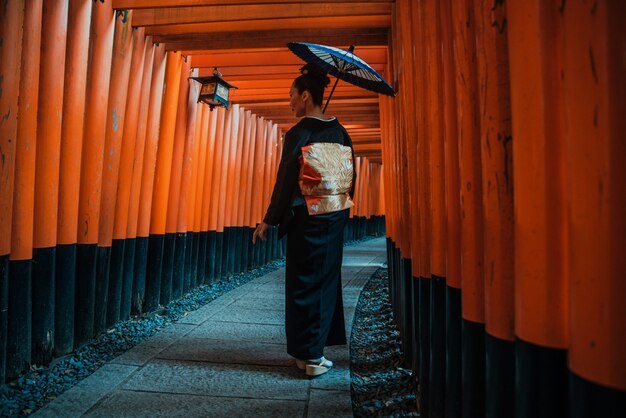 Bella donna senior giapponese che cammina nel santuario di inari di fushimi a Kyoto