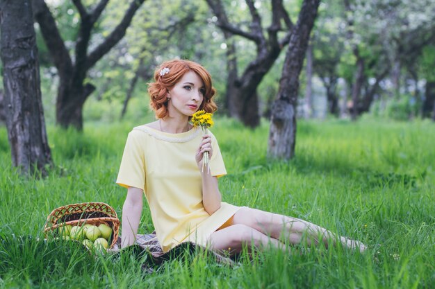 Bella donna sensuale con capelli rossi nel giardino di primavera