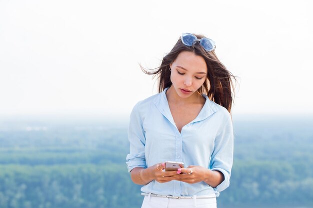 Bella donna sensuale sexy con smartphone a portata di mano in natura