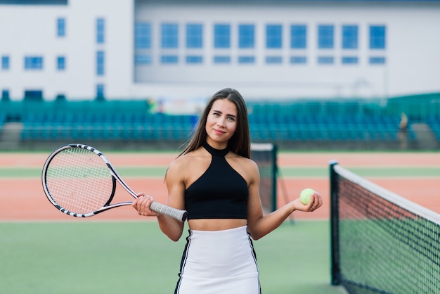 Bella donna sexy alla moda in un abbigliamento sportivo alla moda sul campo da tennis.