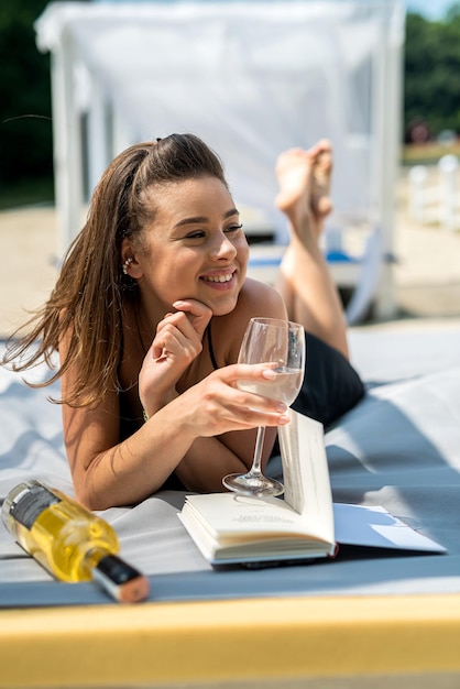 Bella donna sexy spensierata sdraiata sul gazebo con tenda bianca sulla spiaggia