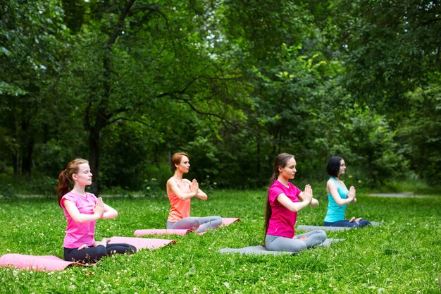 Bella donna sorridente che fa yoga nel parco.