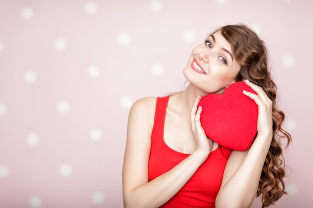 Bella donna sorridente con cuori rossi per il giorno di San Valentino