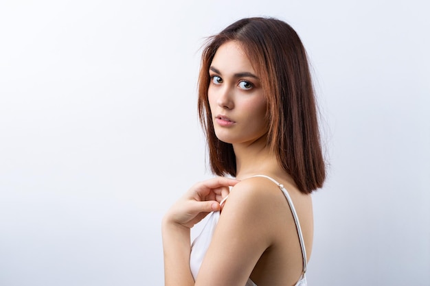 Bella donna sorridente con trucco naturale della pelle pulita e denti bianchi su sfondo grigio