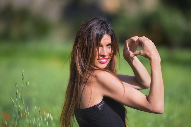 Bella donna sorridente. Simbolo del cuore a forma di Concetto di amore e natura. Ecologia e sostenibilità.