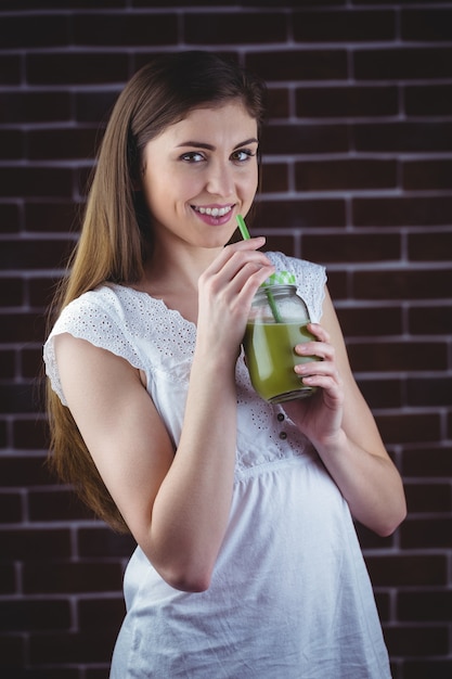 Bella donna sorseggiando succo verde