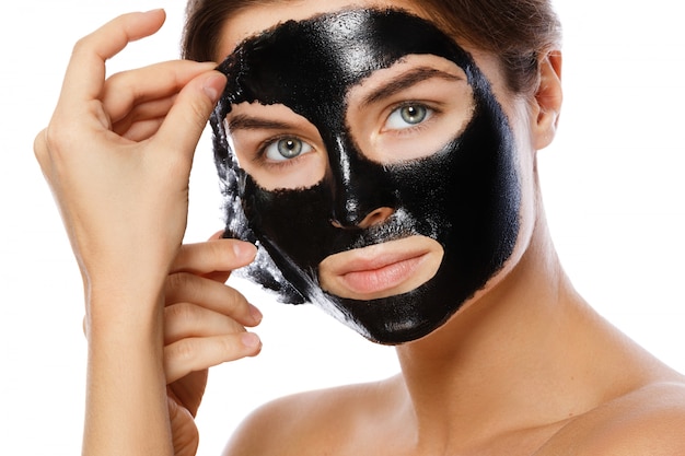 Bella donna sta rimuovendo la maschera purificatrice dal viso