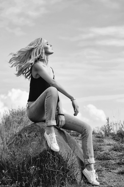 Bella donna su pietra e cielo blu