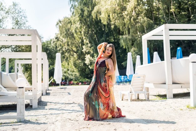 Bella donna sulla spiaggia e posa in abito di menta