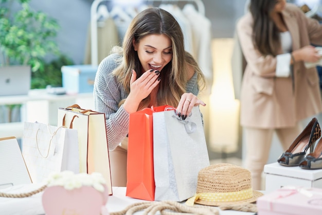 Bella donna sullo shopping nel negozio di vestiti. Foto di alta qualità