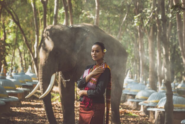 Bella donna tailandese che passa tempo con l'elefante nella giungla