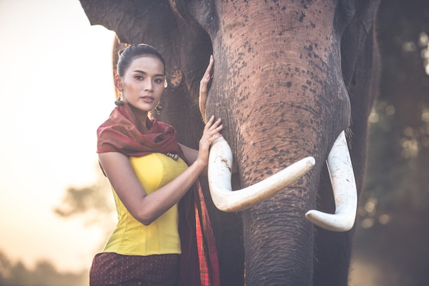 Bella donna tailandese che passa tempo con l'elefante nella giungla