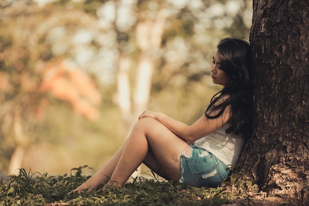 Bella donna tailandese molto triste per l'amore non corrisposto, ripensa e ripensa all'amore in stile vintage tono scuro ragazza asiatica con il cuore spezzato pensa molto perché è grassa