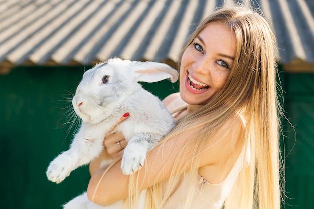 Bella donna tenere bianco coniglio Ritratto di giovane donna in posa con il coniglio