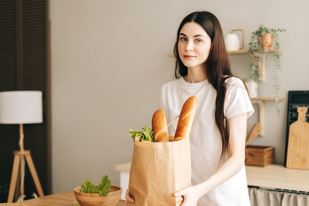 Bella donna tenere eco shopping bag con verdure fresche e baguette