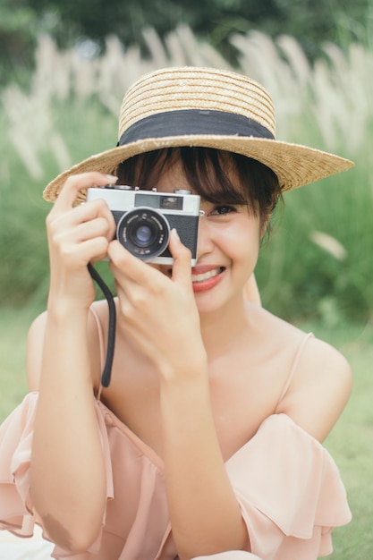 Bella donna tenere macchina fotografica d'epoca in giardino