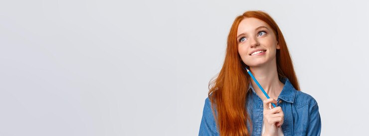Foto bella e creativa premurosa donna rossa sorridente sognante che guarda in alto e pensa di immaginare qualcosa