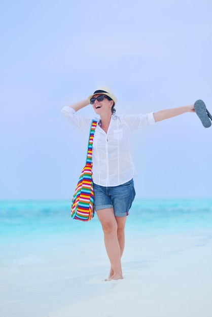 bella e felice donna ragazza sulla spiaggia divertirsi e rilassarsi durante le vacanze estive sul bellissimo mare tropicale