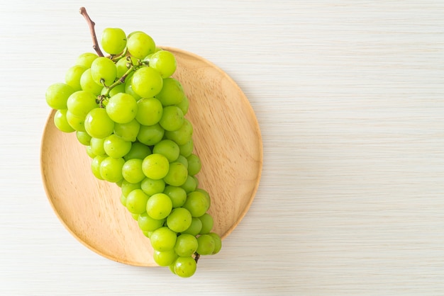 bella e fresca uva verde su piatto di legno