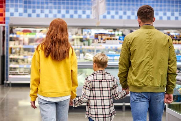 Bella e giovane famiglia facendo shopping insieme