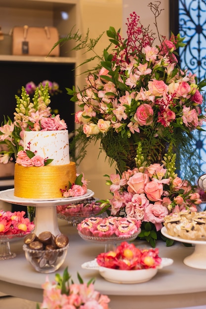 Bella e lussuosa torta nuziale e tavolo dei dolci