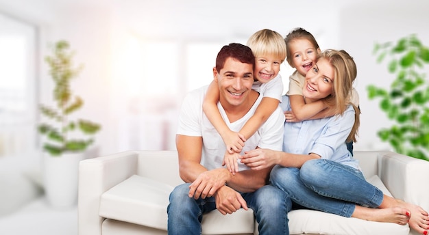 Bella famiglia adorabile sorridente che si siede sul sofà