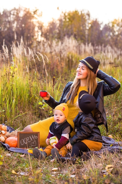 Bella famiglia con un cane golden retriever durante una passeggiata nella natura soleggiata autunnale