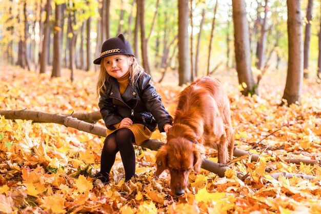 Bella famiglia con un cane golden retriever durante una passeggiata nella natura soleggiata autunnale