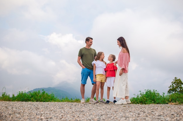 Bella famiglia felice in montagna sullo sfondo della nebbia