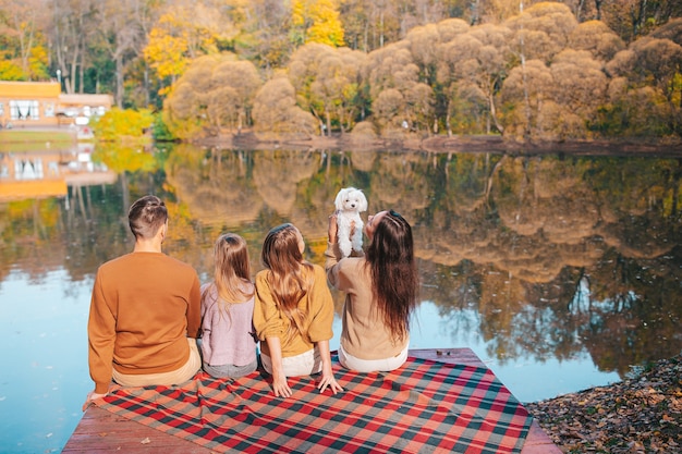 Bella famiglia in autunno caldo giorno vicino al lago