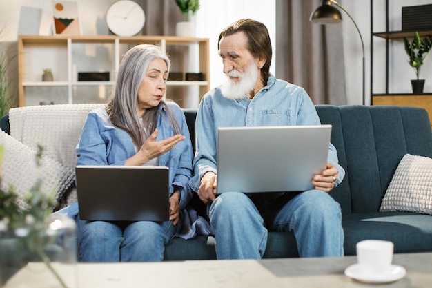 Bella famiglia invecchiata sedersi sul divano utilizzando il computer portatile