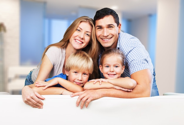 Bella famiglia sorridente in camera sul divano