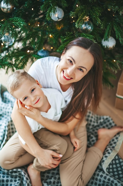 Bella famiglia sorridente sotto l'albero di Natale