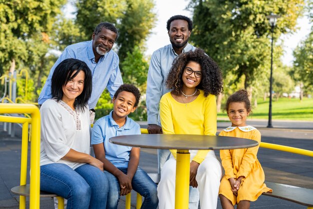 Bella felice famiglia afroamericana che si unisce al parco Famiglia nera che si diverte all'aperto