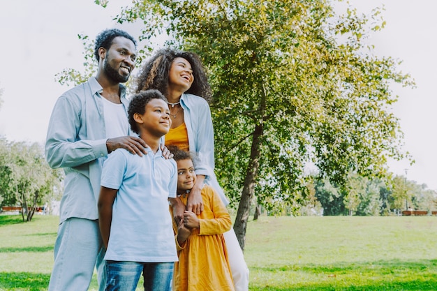 Bella felice famiglia afroamericana che si unisce al parco Famiglia nera che si diverte all'aperto