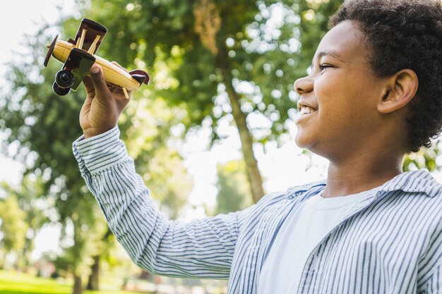 Bella felice legame familiare afroamericano al parco - Famiglia nera che si diverte all'aperto, ragazzo carino che gioca con il giocattolo dell'aeroplano