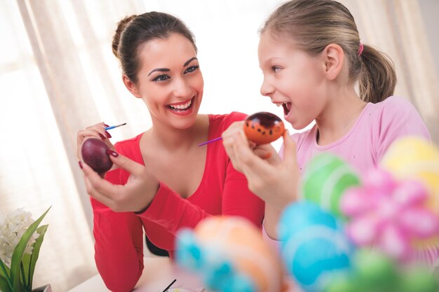 Bella felicità madre e figlia che dipingono l'uovo di Pasqua a casa.