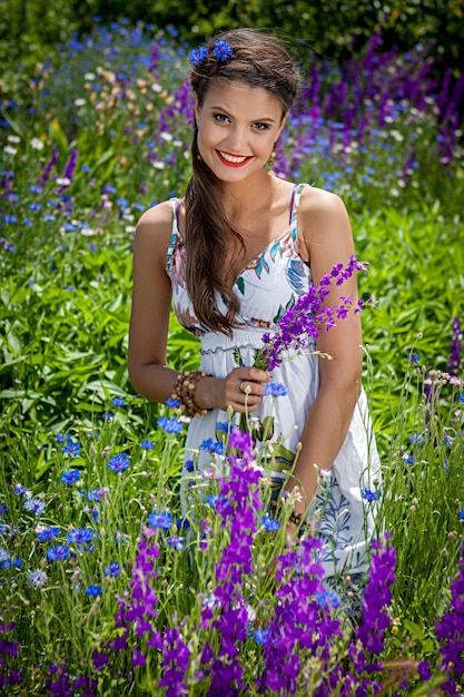Bella femmina felice nei fiori di campo