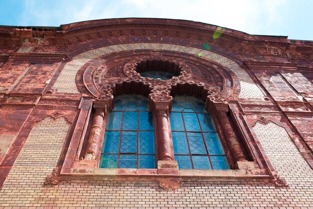 Bella finestra di modanatura in stucco sulla facciata della chiesa con il bagliore del sole a Uzhgorod