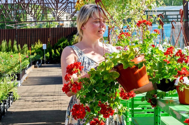 Bella fiorista femminile lavora con i fiori in un centro di giardinaggio.