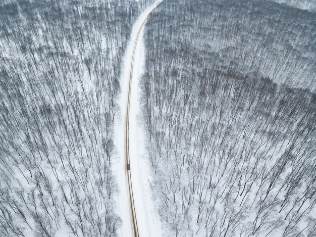 Bella foto panoramica da drone sopra un fantastico paesaggio invernale con neve sulla foresta e sulla strada