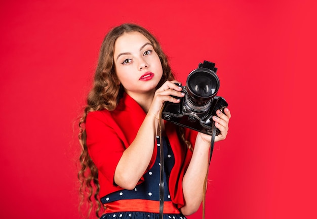 Bella fotocamera bambino tenere fotocamera retrò. giornalista è la mia futura carriera. piccolo giornalista fare foto. macchina fotografica d'epoca. ragazza con fotocamera retrò. catturare ricordi d'infanzia. Fotocamera reflex.