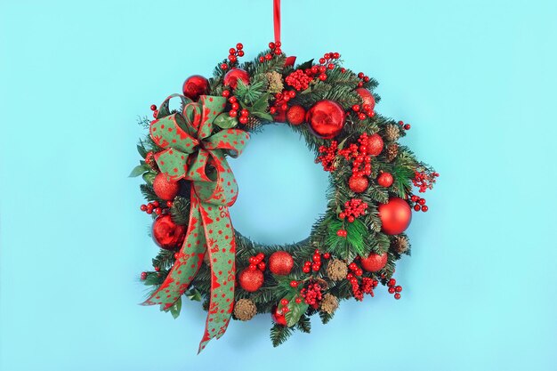 Bella ghirlanda di Natale fatta a mano con decorazioni festive su sfondo blu Composizione natalizia