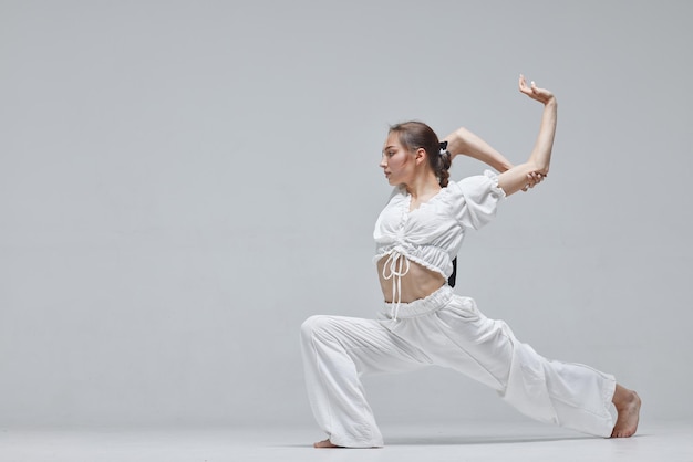 Bella giovane ballerina moderna o ballerina di fitness su uno sfondo bianco isolato