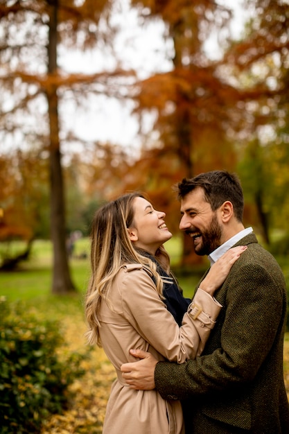 Bella giovane coppia che cammina nel parco autunnale