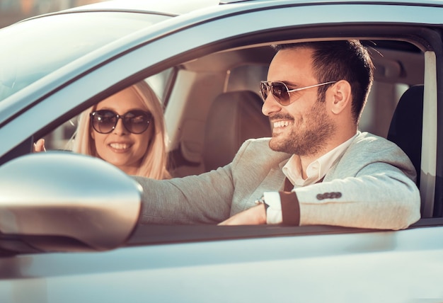 Bella giovane coppia felice che guida l'auto