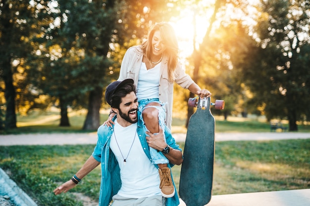 Bella giovane coppia godendo all'aperto nel parco di skateboard della città.