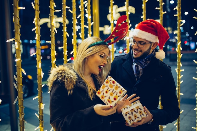 Bella giovane coppia innamorata che si gode la notte di Natale o Capodanno in una strada cittadina.