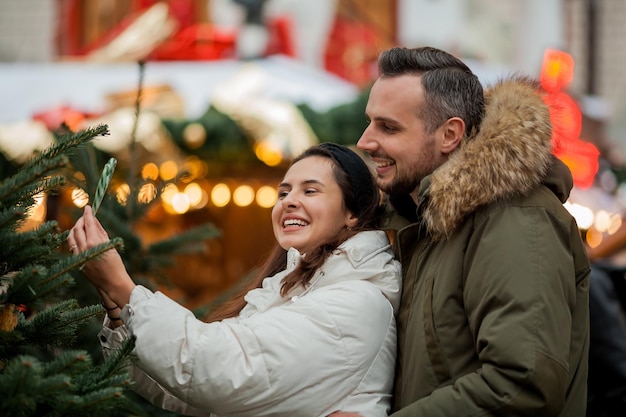 Bella giovane coppia tradizionale felice al mercatino di Natale Vacanze invernali Vacanze in Europa Capodanno